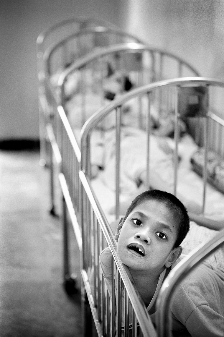 handicapped orphan boy in crib - ho chi minh city vietnam