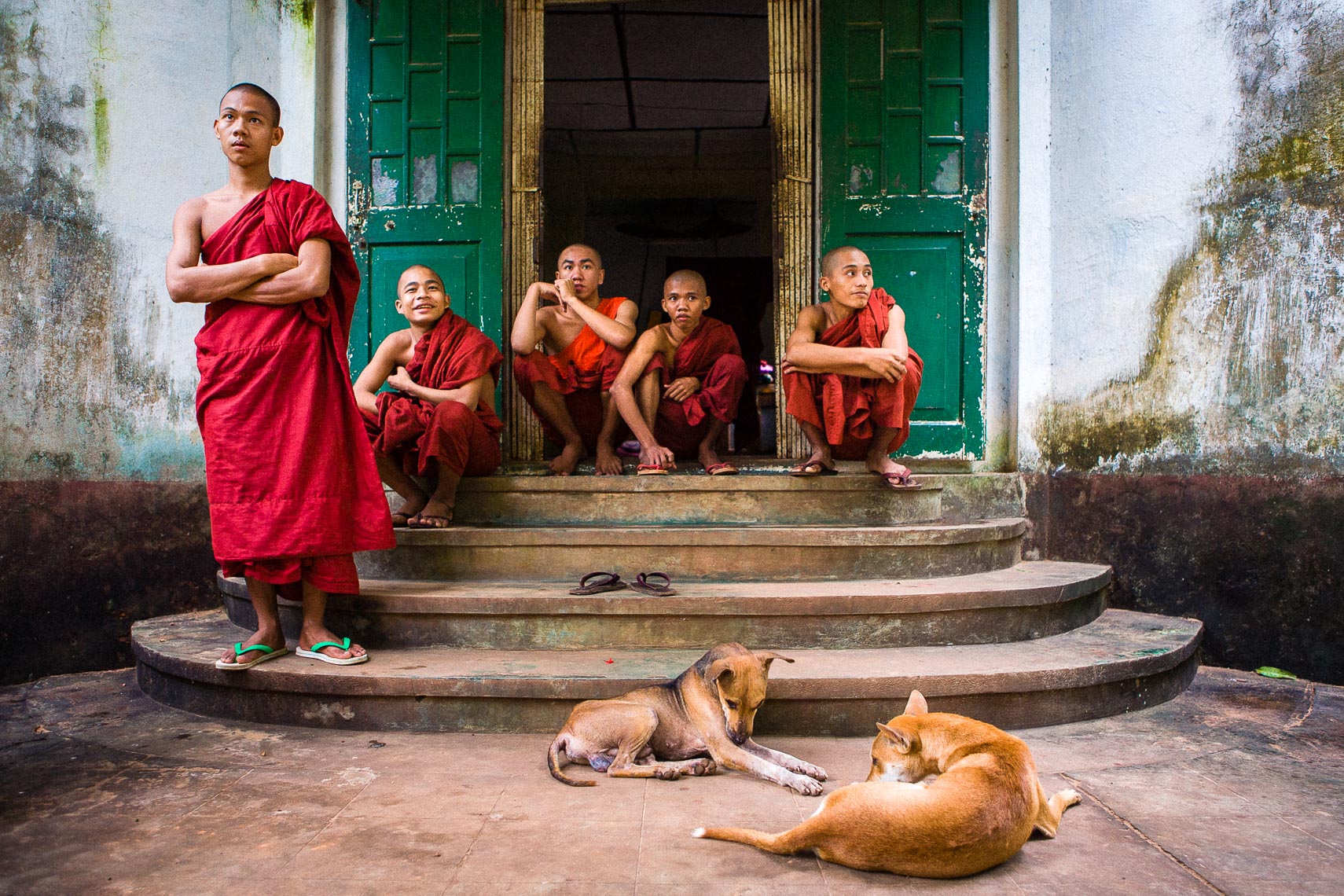 group of young monks sit on steps of temple in burma myanmar