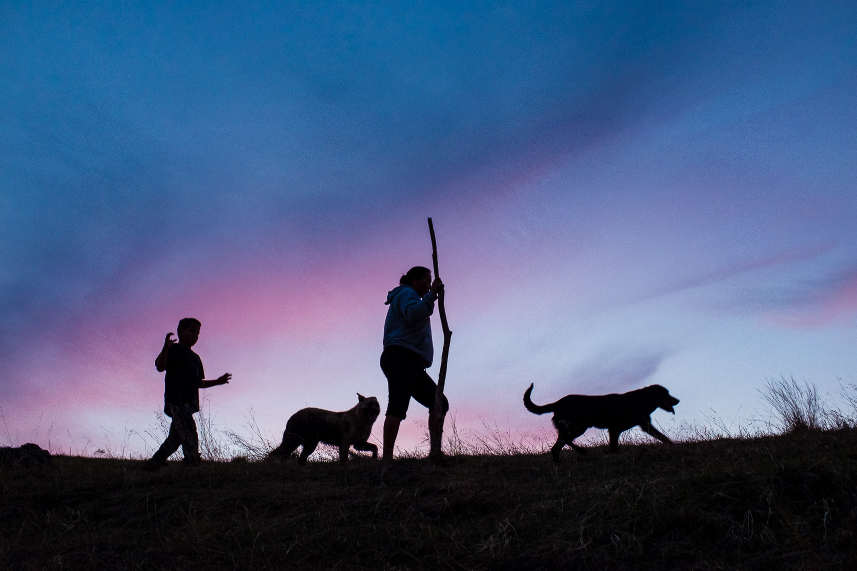 grandmother and grandson walk along a ridge at sunset on the pine ridge indian reservation Oglala Sioux nation