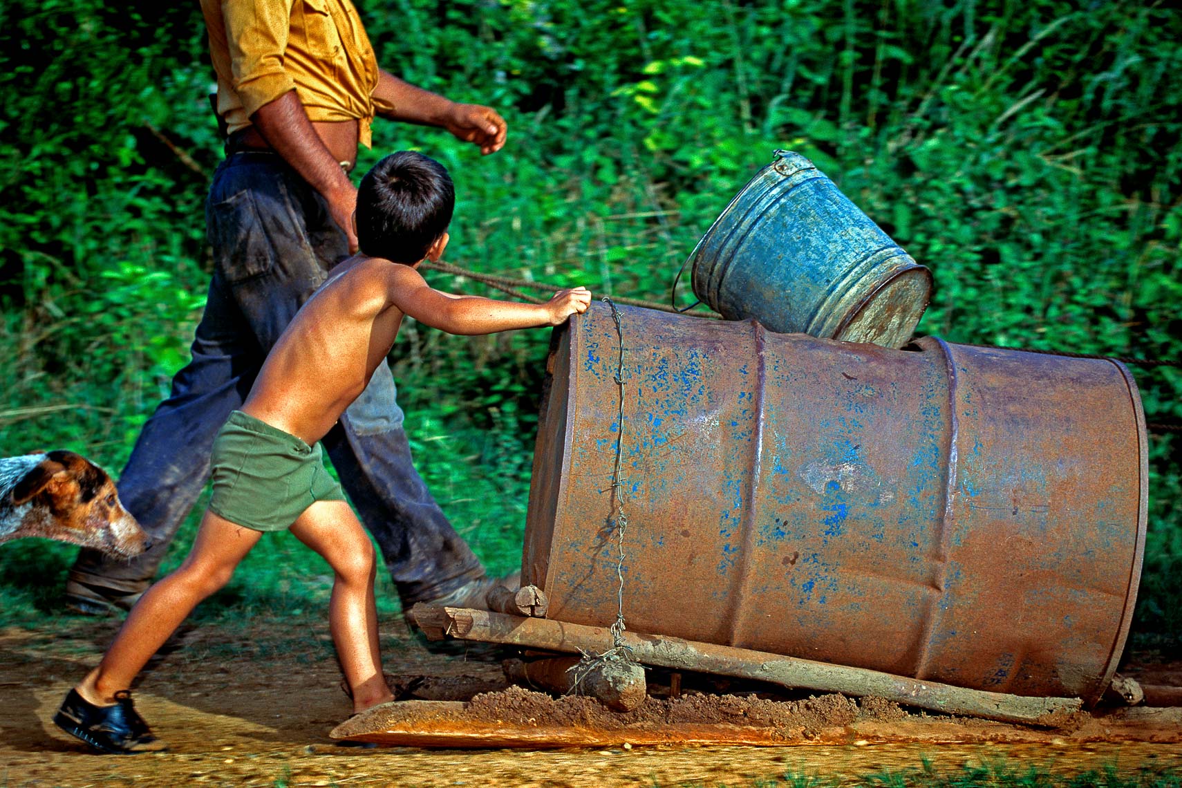 cuban boy and father man fetch water from the river