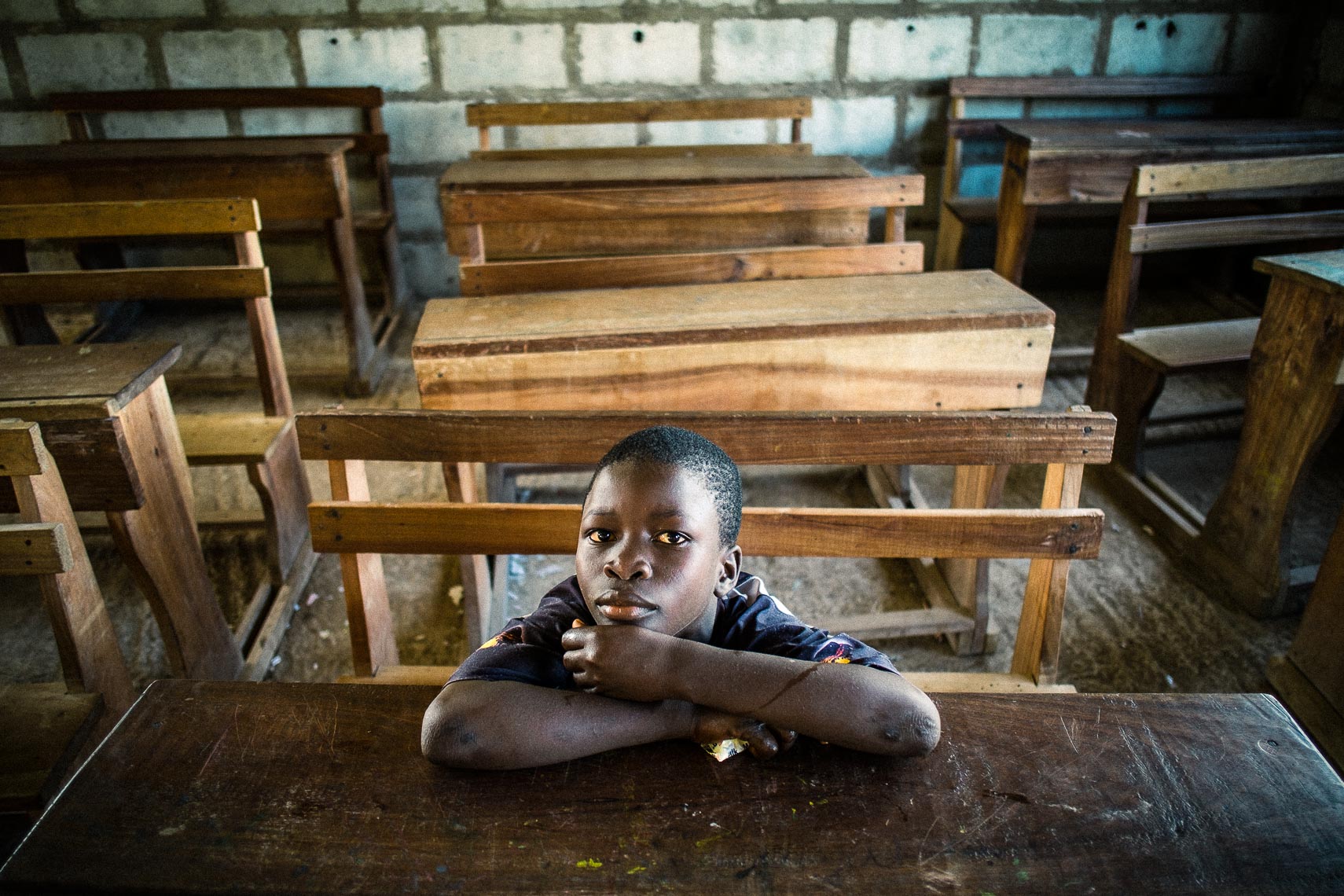 orphan boy at desk ready for class - city of refuge - tema ghana