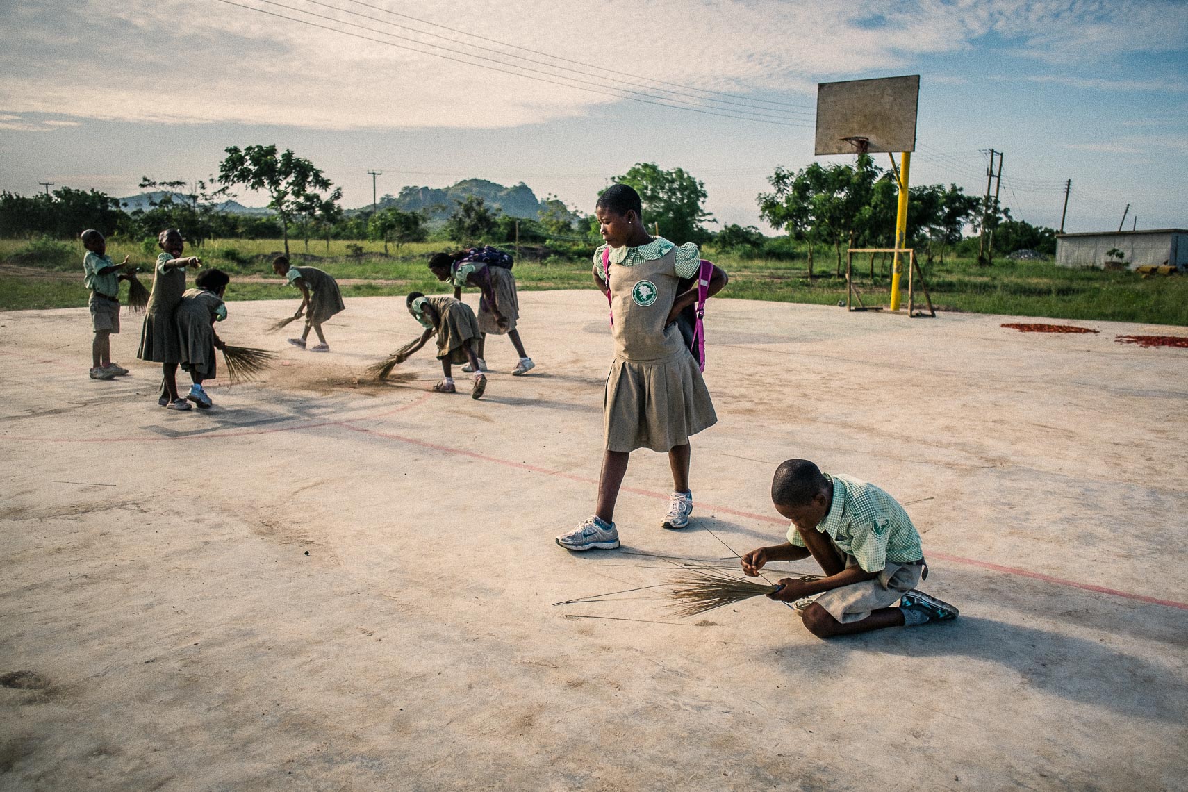 sweeping the basketball court - city of refuge - tema ghana