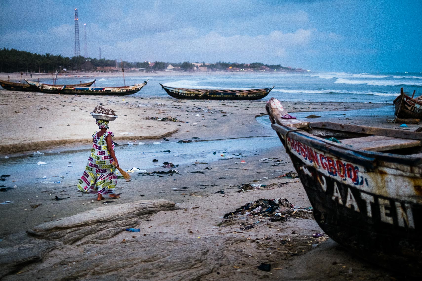 woman carries her dried fish to market in a basket on her head - teshie nungua