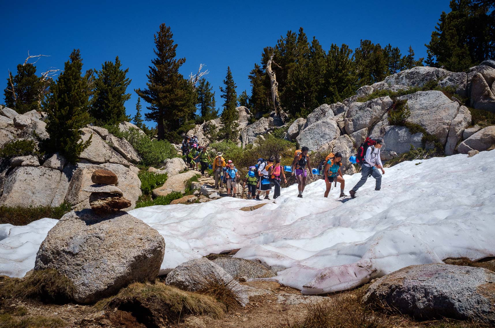 students from the woods project pass a rock pile cairn bear the treeline of yosemite